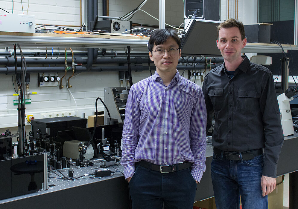 Bild (Department Physik): Dr. Guixin Li (links) und Prof. Thomas Zentgraf (rechts) im Laserlabor an der Universität Paderborn.