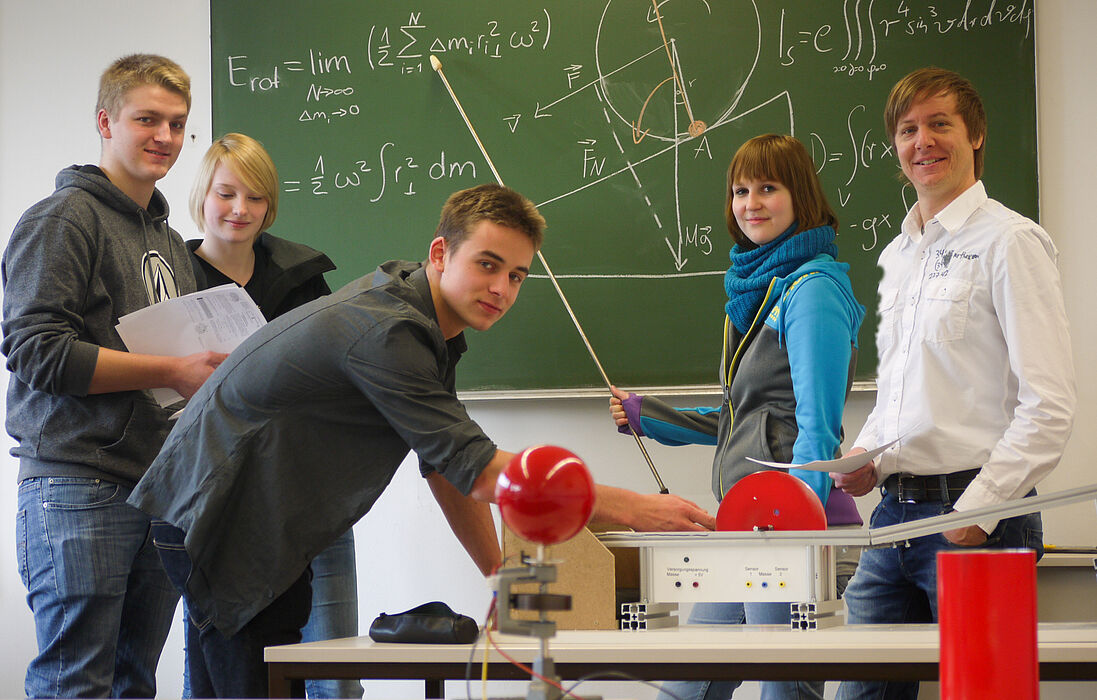 Foto (Department Physik): Physik-Studierende und Dr. Marc Sacher, Studienberater und Leiter des Physikalischen Grundpraktikums, gemeinsam im Labor.