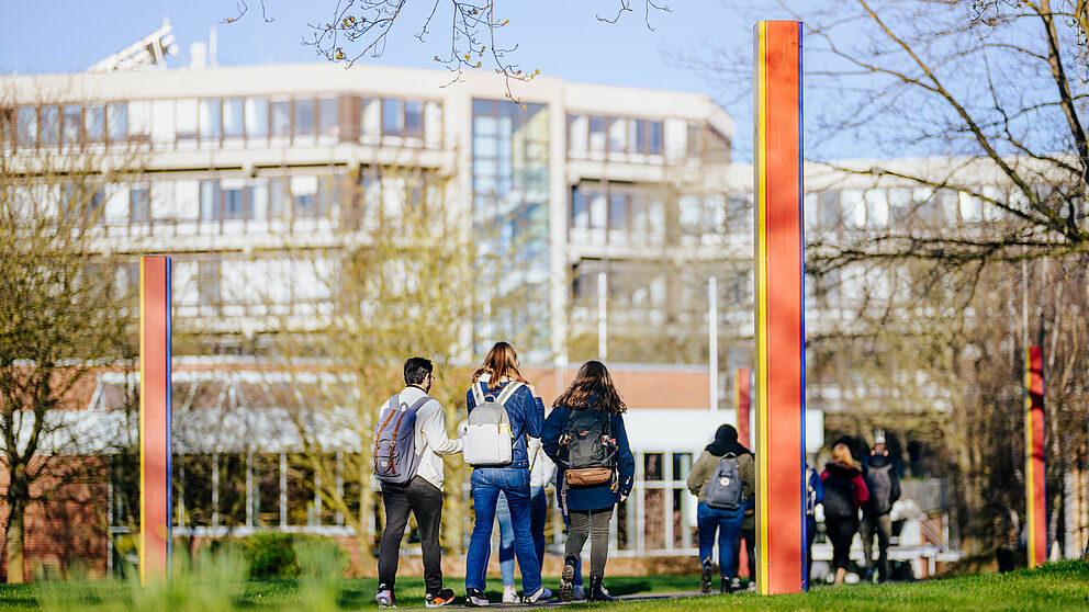 Group of people and colored stelae on the campus of Paderborn University.