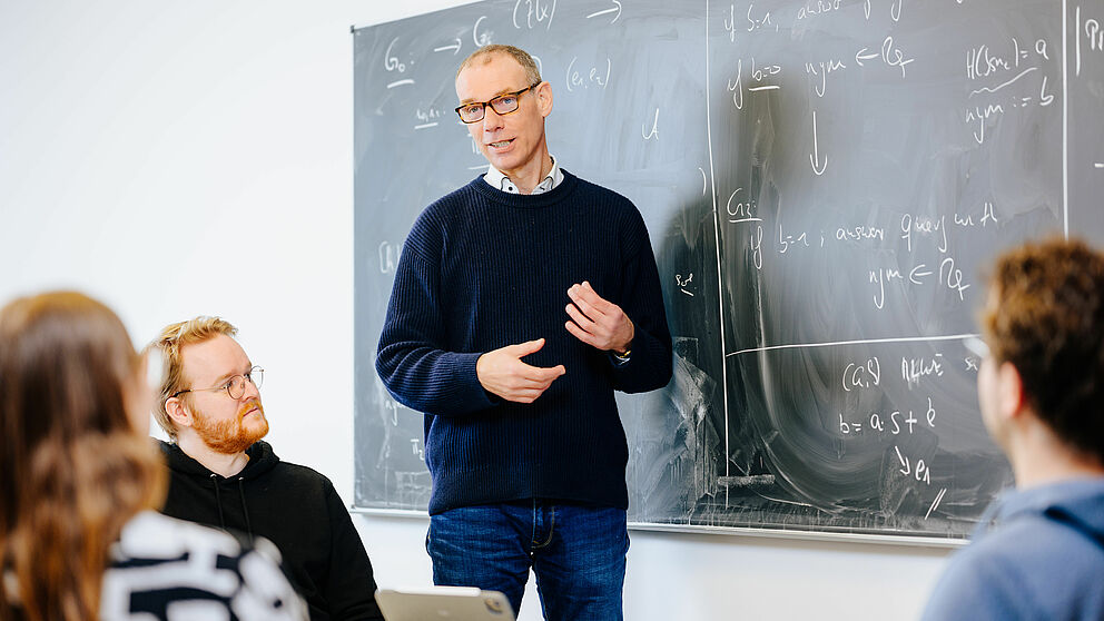 Prof. Dr. Johannes Blömer teaching in front of a blackboard.